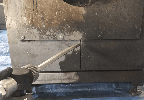 Before/after of smoke-stained ceiling joists cleaned to bright wood