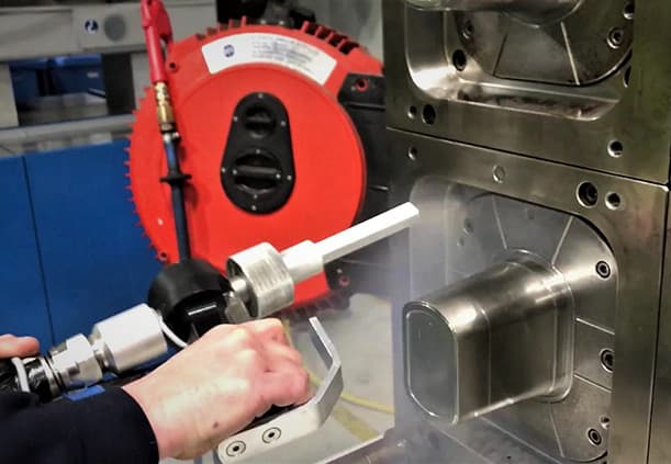 Parting line vent holes being cleaned with a fine nozzle