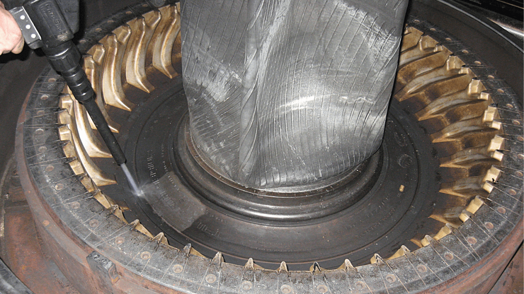 Technician performing in-press dry-ice cleaning of a tire mold