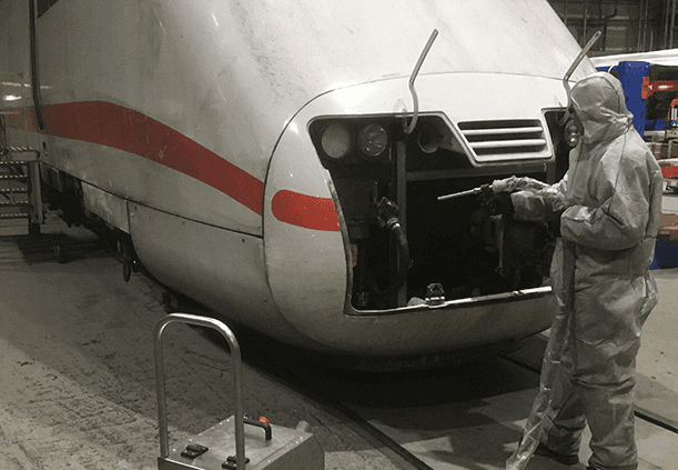 Technician using a dry-ice blaster inside a bus cabin during quick-turn maintenance